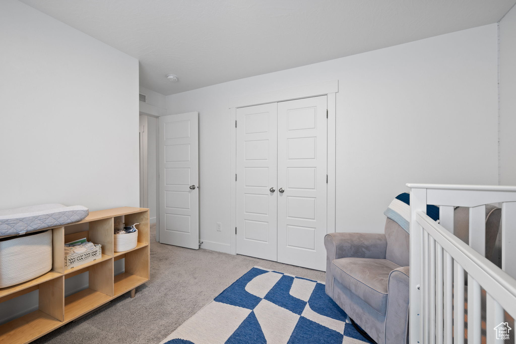 Bedroom with light carpet and a closet