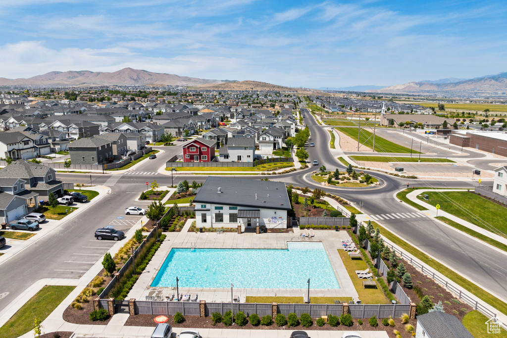 Aerial perspective of suburban area with a pool and a mountainous background