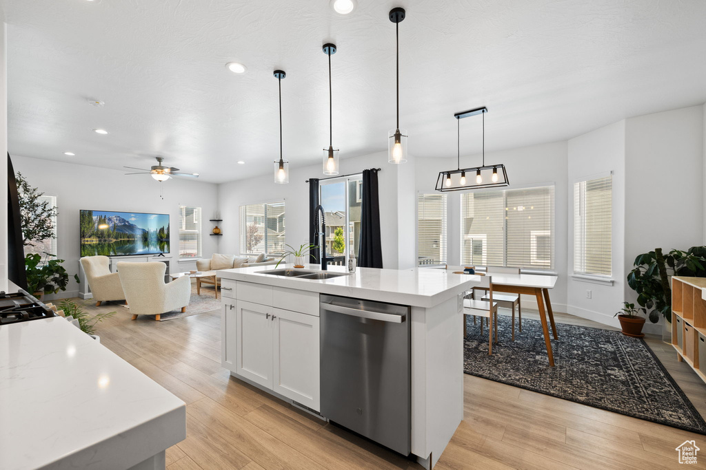 Kitchen featuring dishwasher, recessed lighting, light wood-type flooring, open floor plan, and white cabinets