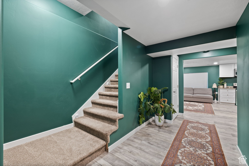 Stairs with wood finished floors and baseboards
