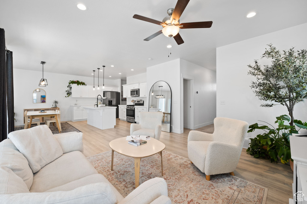 Living room featuring a ceiling fan, light wood finished floors, and recessed lighting
