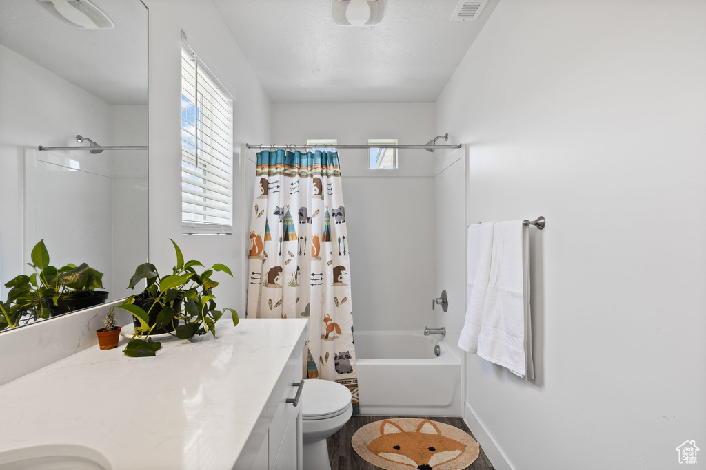 Full bathroom with vanity, shower / bath combo with shower curtain, and wood finished floors