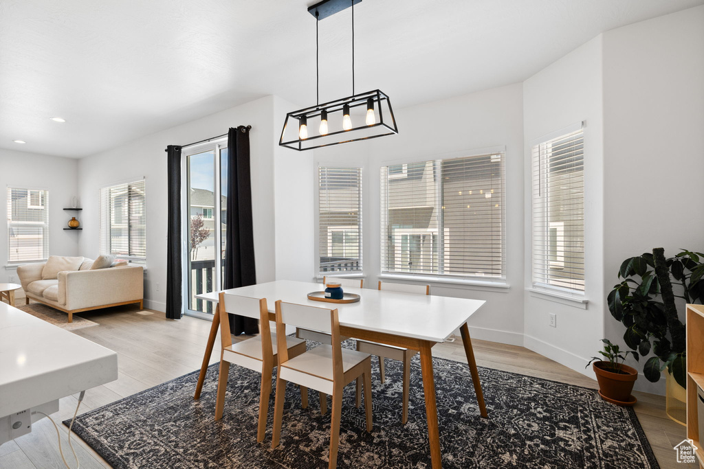 Dining space featuring healthy amount of natural light, light wood-style floors, a chandelier, and recessed lighting