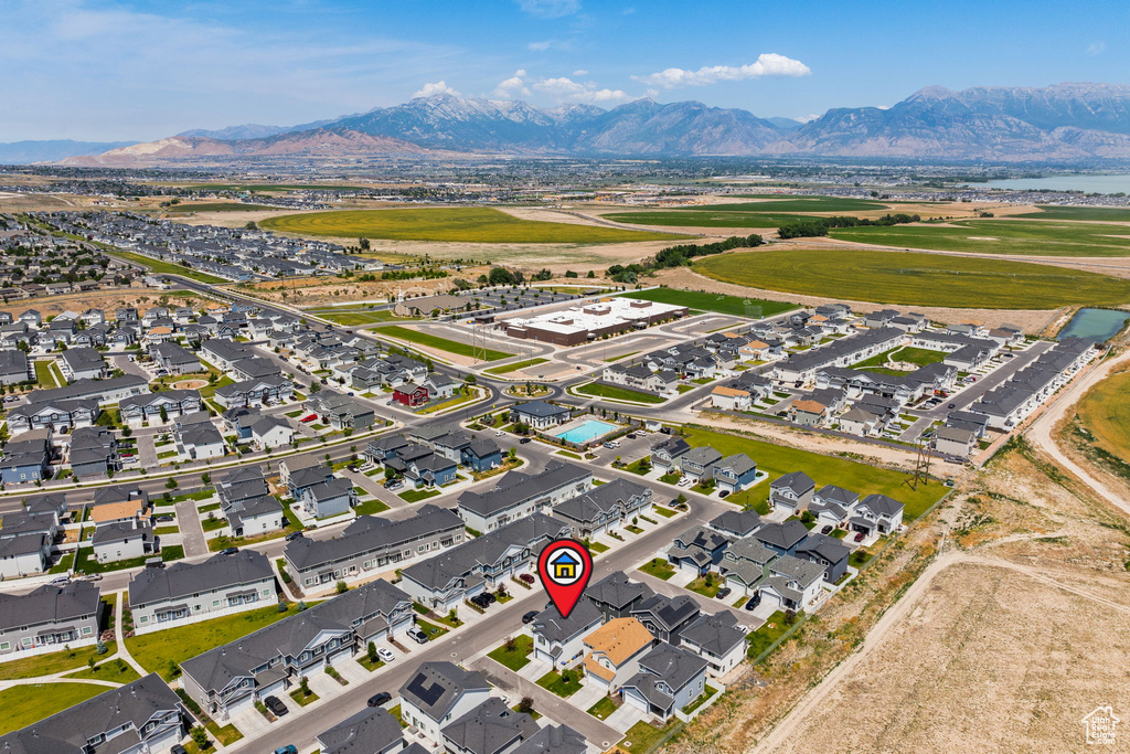 Aerial view of property and surrounding area with a mountain backdrop and nearby suburban area