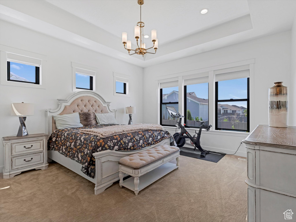Bedroom featuring a chandelier, multiple windows, light colored carpet, a raised ceiling, and recessed lighting