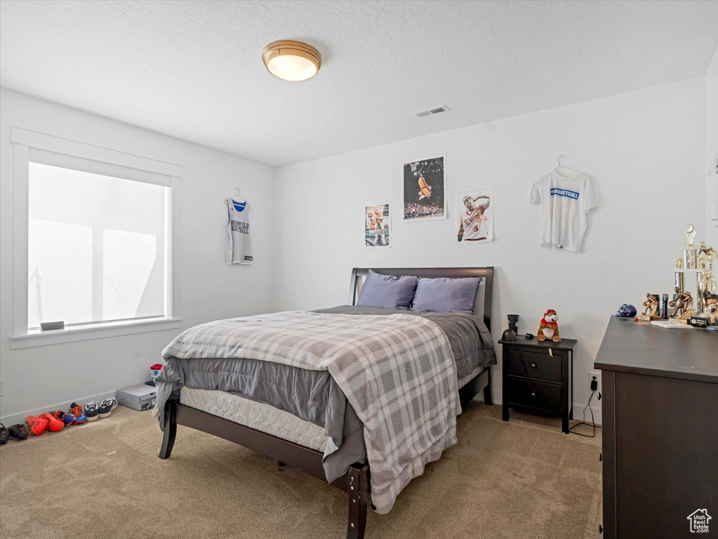 Bedroom featuring light colored carpet and baseboards