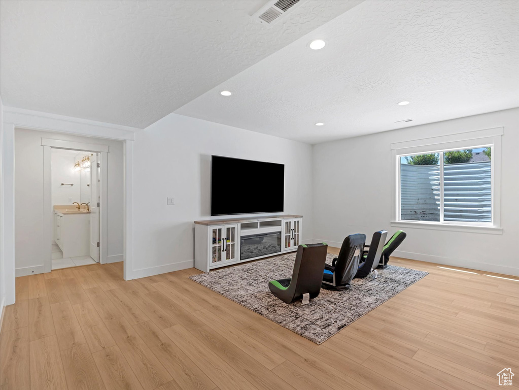 Living area featuring wood finished floors, recessed lighting, and a textured ceiling