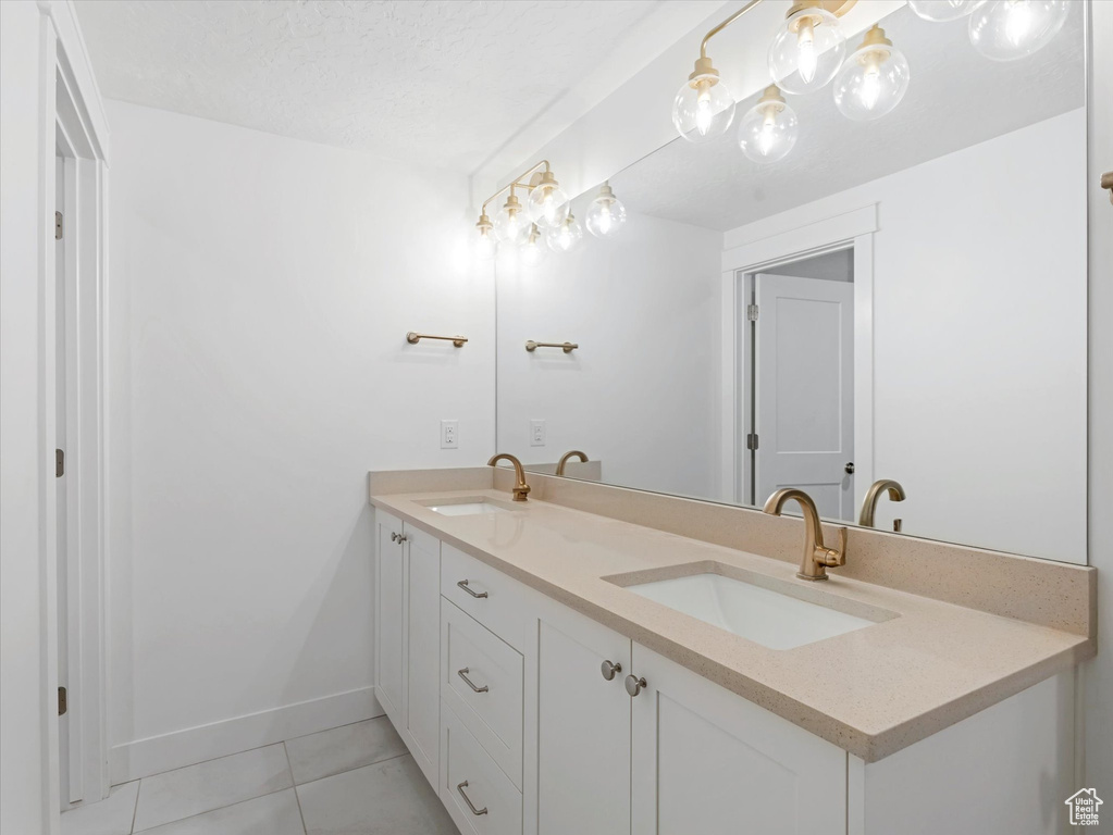Bathroom with double vanity and tile patterned flooring