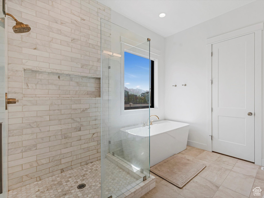 Bathroom featuring a tile shower and a soaking tub