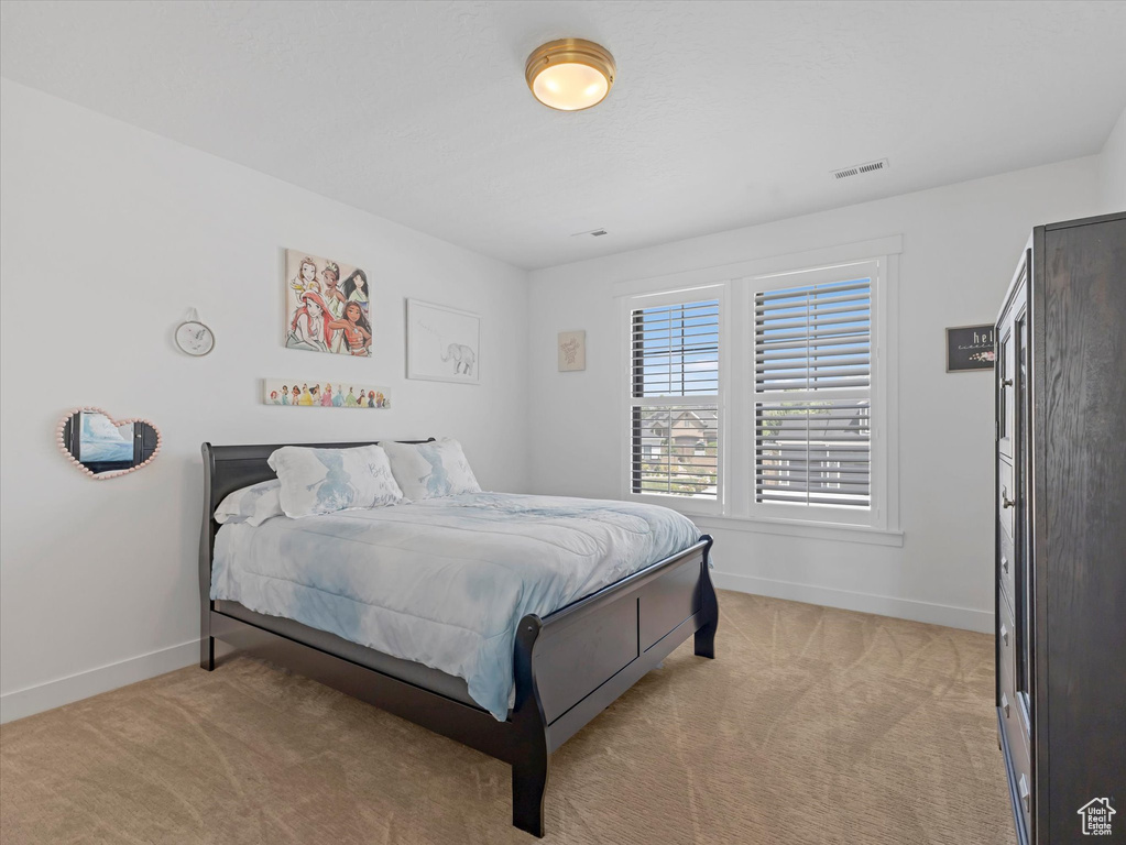 Bedroom with baseboards and light colored carpet