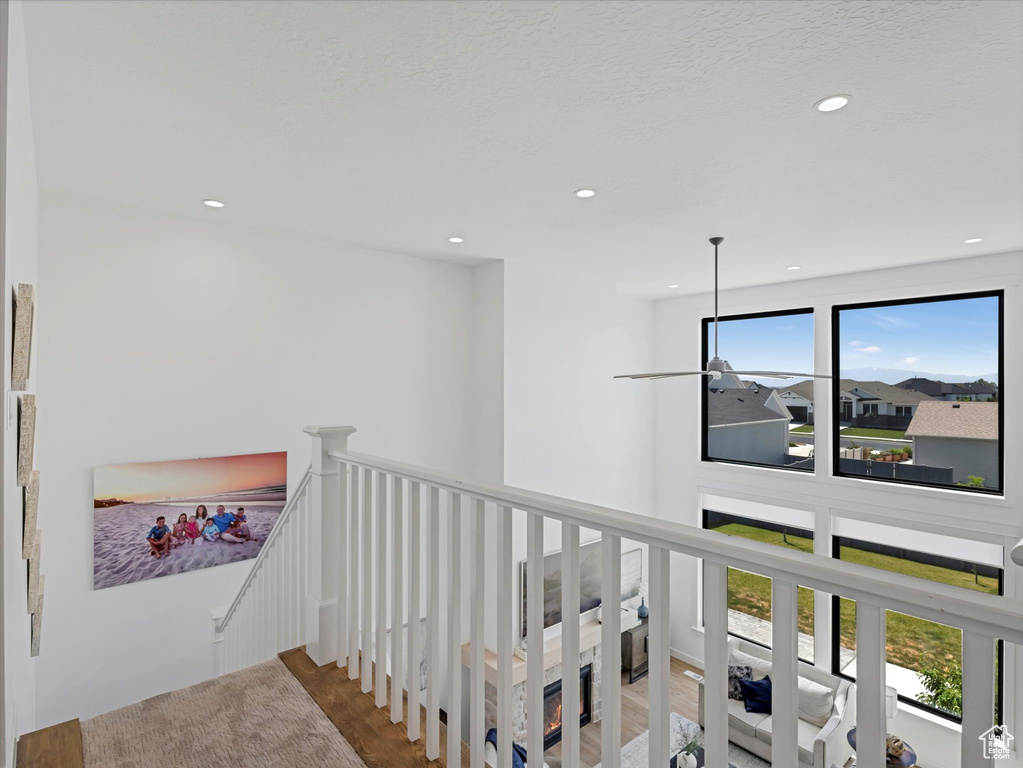 Corridor featuring an upstairs landing, recessed lighting, and wood finished floors