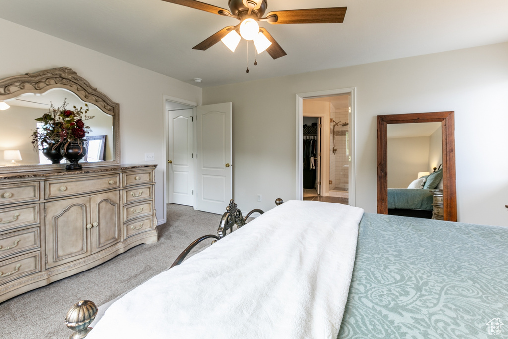 Bedroom featuring light colored carpet, connected bathroom, and ceiling fan