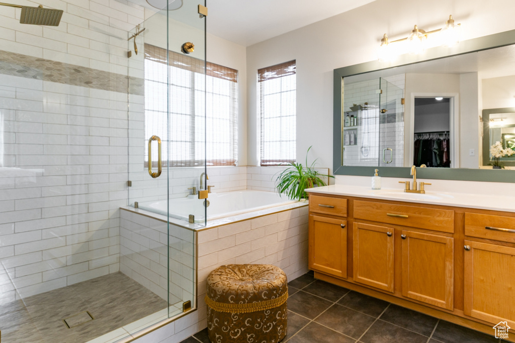 Bathroom featuring tile patterned flooring, vanity, a shower stall, a bath, and a spacious closet