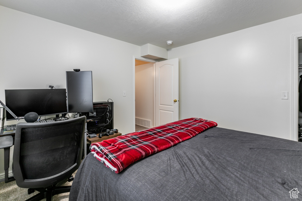 Carpeted bedroom featuring a desk