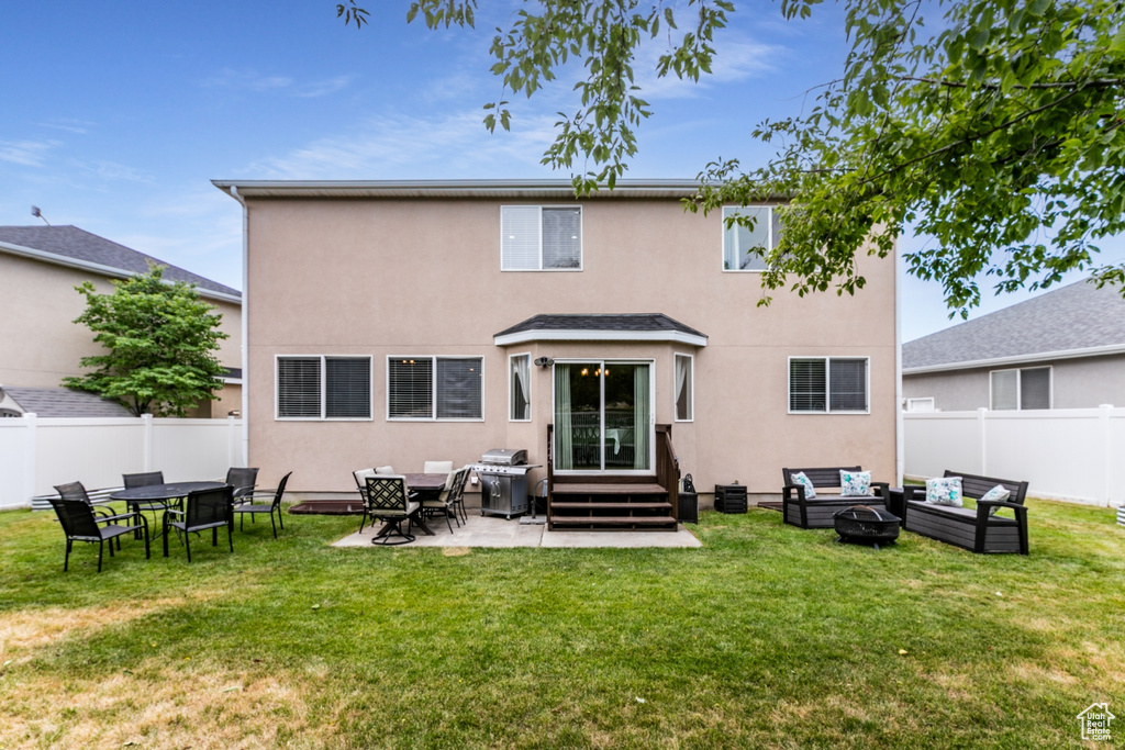 Back of property featuring an outdoor living space with a fire pit, stucco siding, a fenced backyard, a patio area, and entry steps