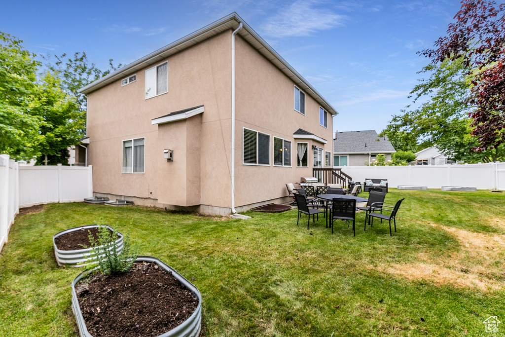Rear view of house with stucco siding and a fenced backyard