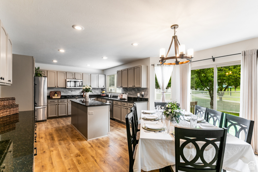 Kitchen featuring stainless steel appliances, a chandelier, a center island, backsplash, and recessed lighting
