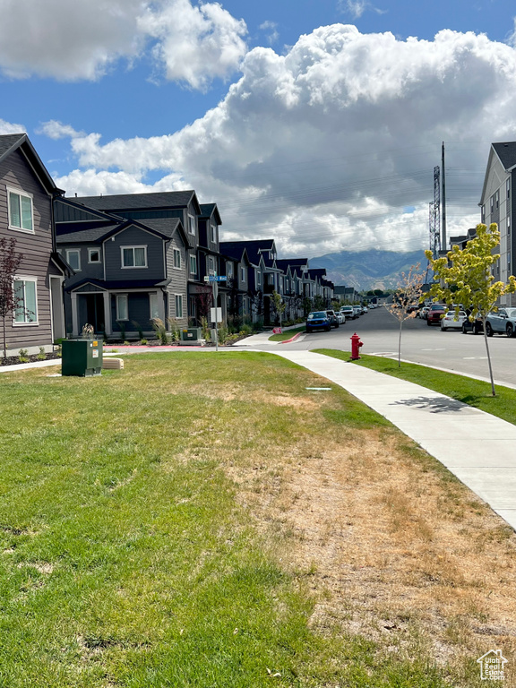 View of green lawn with a residential view