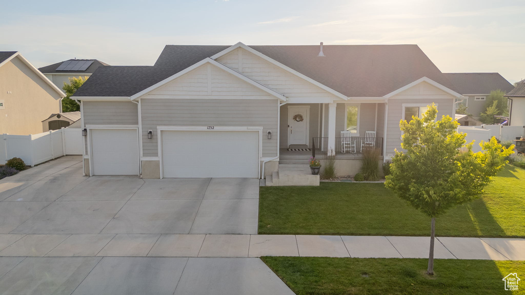 View of front of house with covered porch, concrete driveway, and a garage