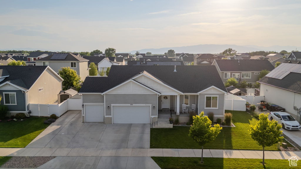 View of front of property with a residential view, a garage, and concrete driveway