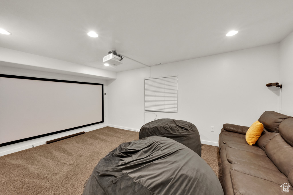 Carpeted cinema room with recessed lighting and baseboards