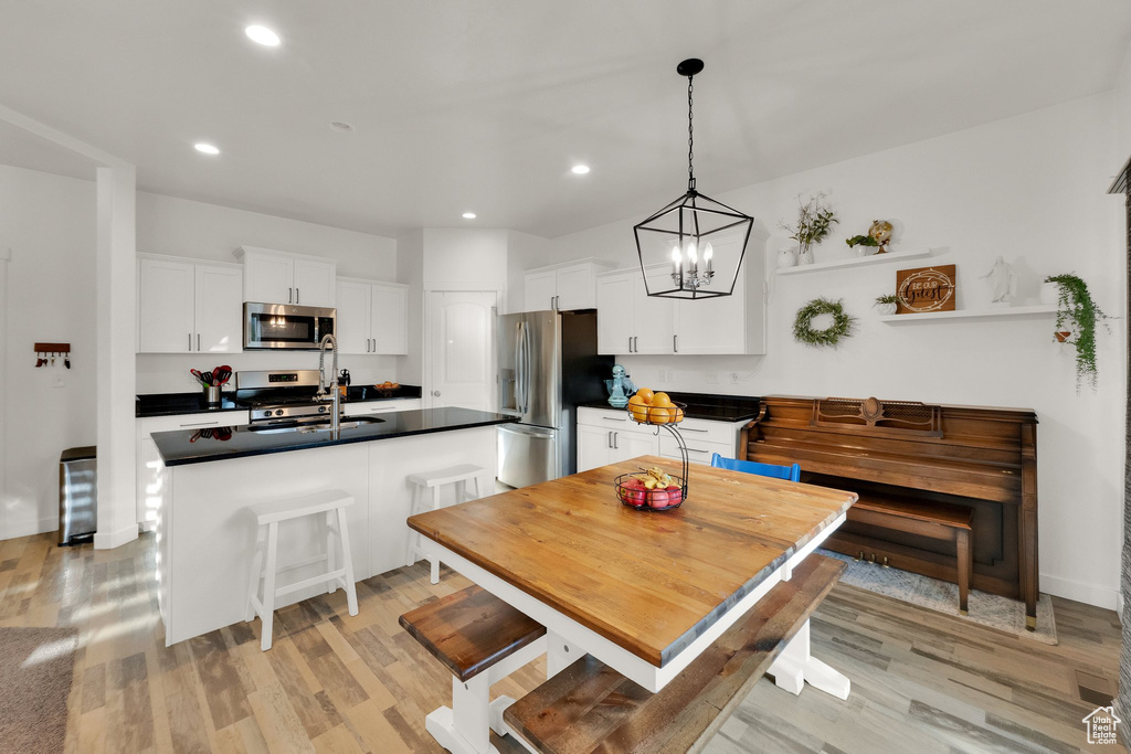 Dining room featuring light wood finished floors, recessed lighting, and a chandelier