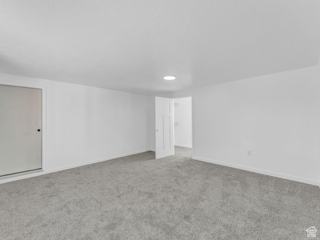 Carpeted empty room with baseboards and recessed lighting