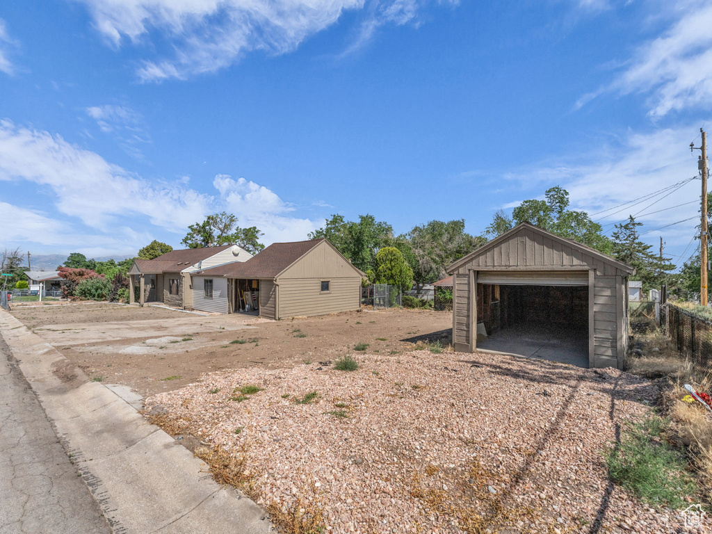 View of side of property with a garage, an outdoor structure, and board and batten siding