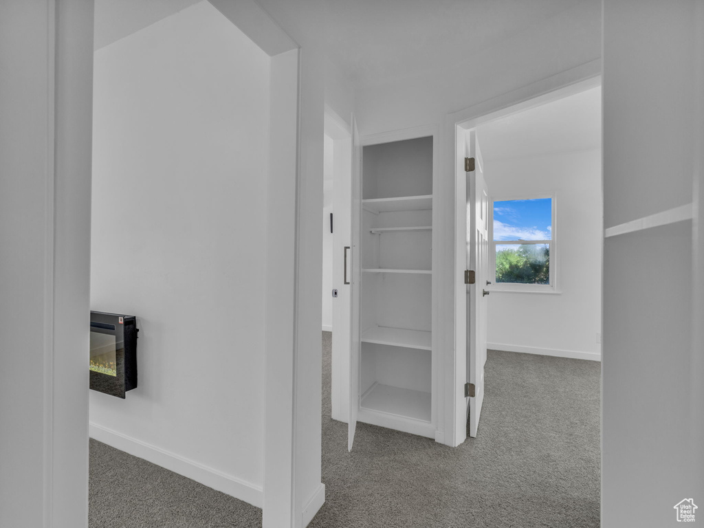 Hallway with carpet flooring and baseboards