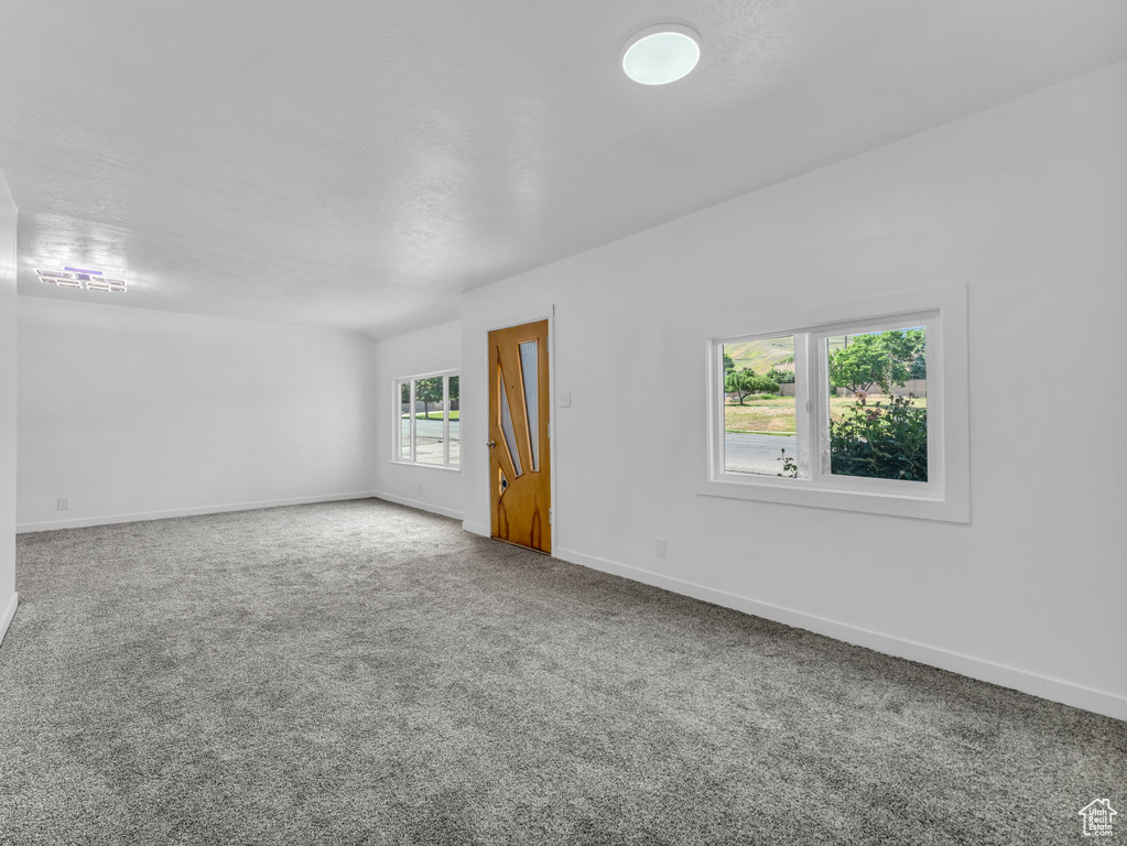 Carpeted spare room featuring baseboards