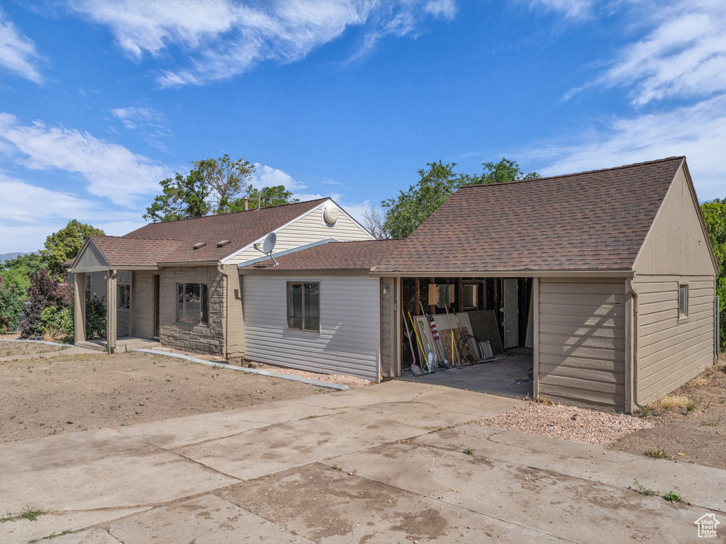 View of front facade featuring driveway and roof with shingles