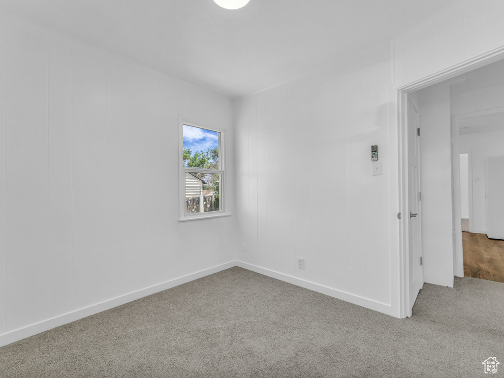 Spare room featuring carpet and baseboards