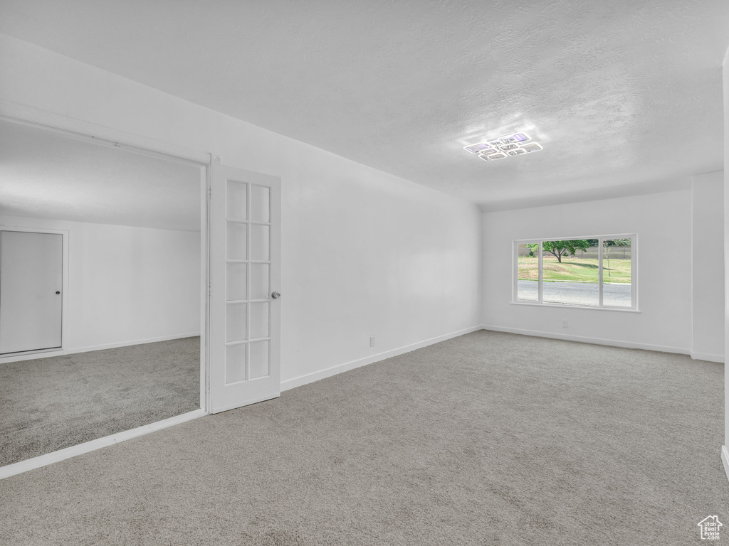 Carpeted empty room with baseboards and a textured ceiling