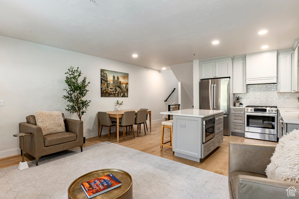 Living area with stairway, light wood-style flooring, and recessed lighting