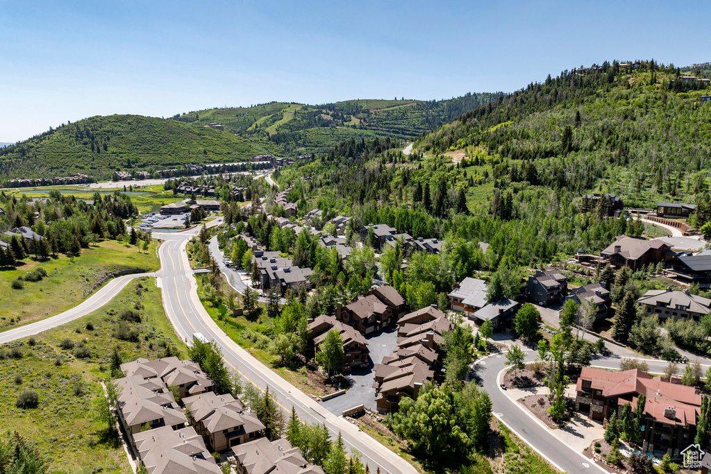 Aerial perspective of suburban area with a mountainous background and a forest