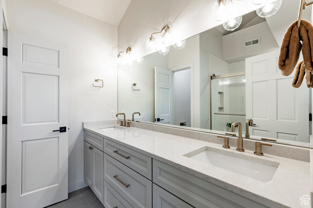 Bathroom with double vanity, a stall shower, and tile patterned floors