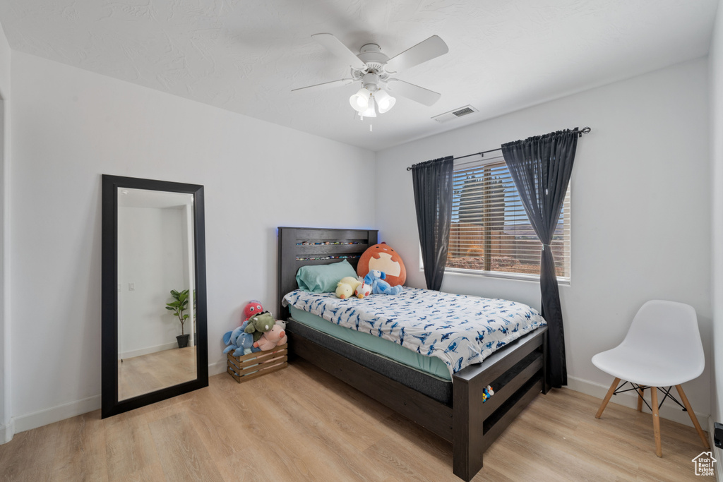 Bedroom with light wood-style floors and a ceiling fan