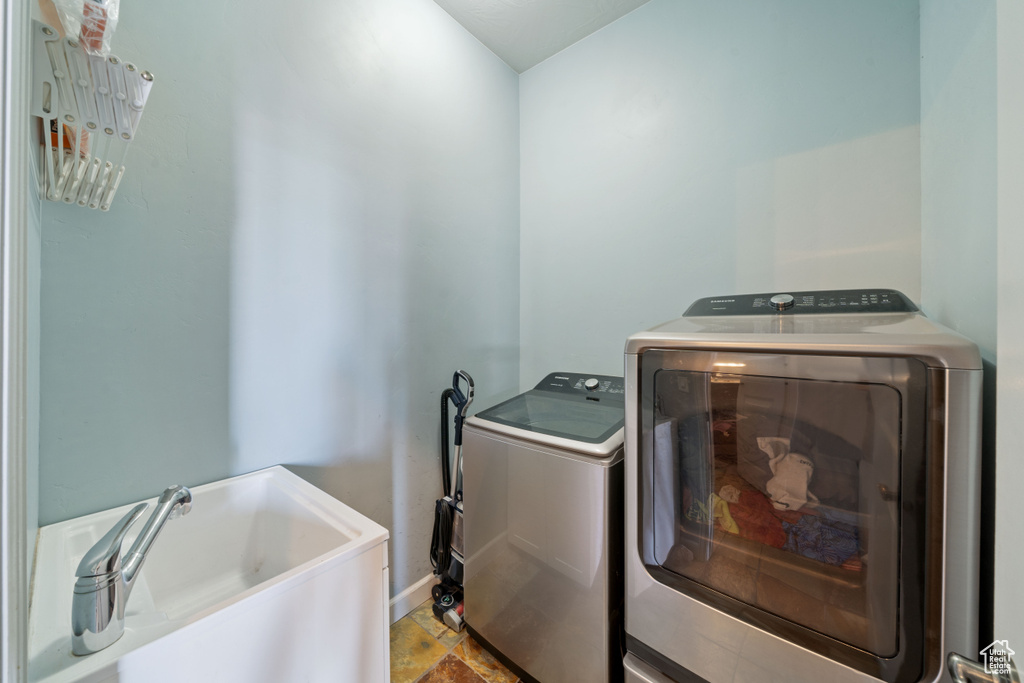 Washroom featuring washing machine and dryer and baseboards