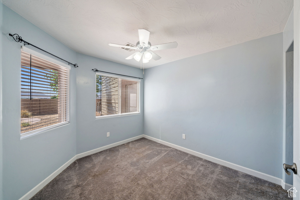 Empty room with carpet floors and a ceiling fan