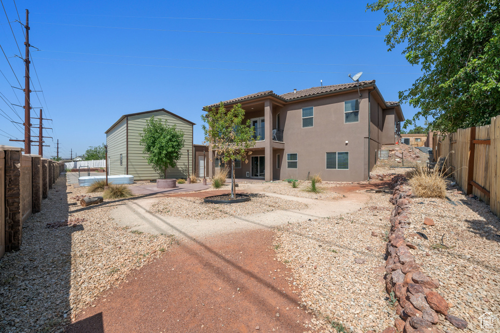 Rear view of property featuring stucco siding, a fenced backyard, and a patio