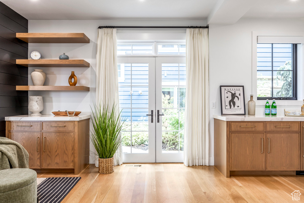 Bar featuring light wood-style floors and french doors