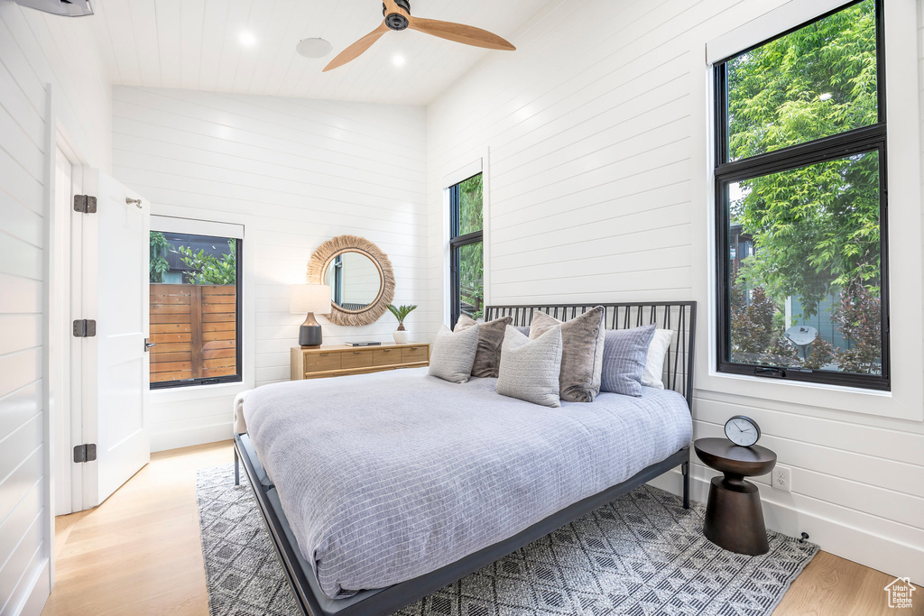 Bedroom with wood finished floors, wooden walls, recessed lighting, and ceiling fan