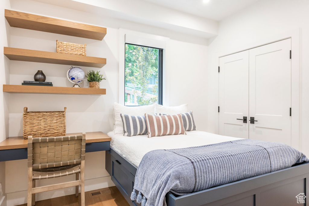 Bedroom with wood finished floors, a closet, and recessed lighting