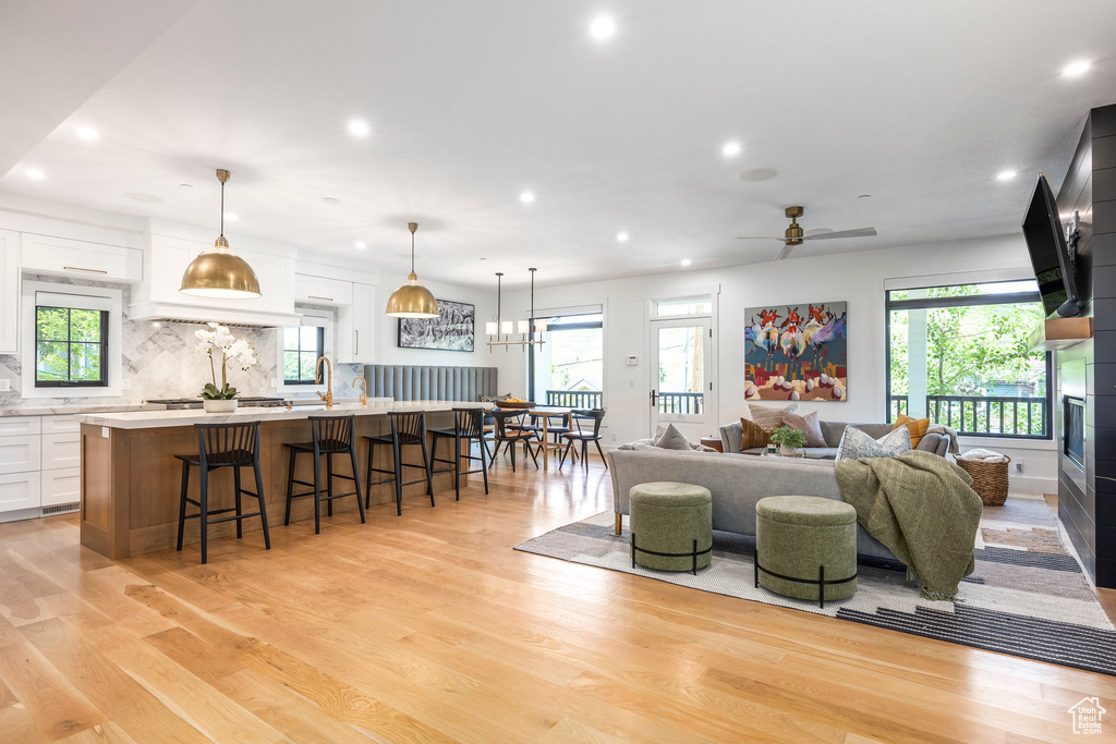Living room featuring light wood-type flooring, recessed lighting, ceiling fan, and a fireplace
