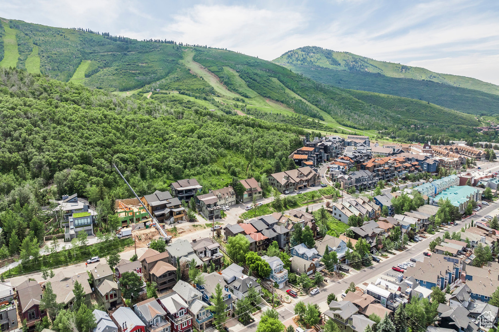 Aerial view of property and surrounding area with a mountainous background and nearby suburban area