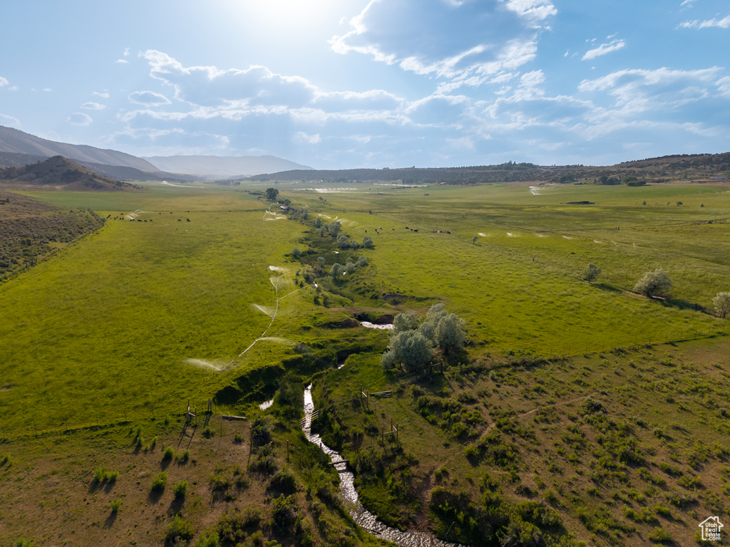 Aerial view of property and surrounding area with rural landscape and a mountainous background