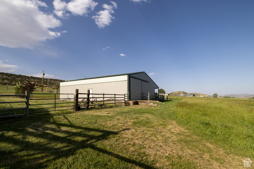 View of yard with a pole building, an outdoor structure, and a rural view