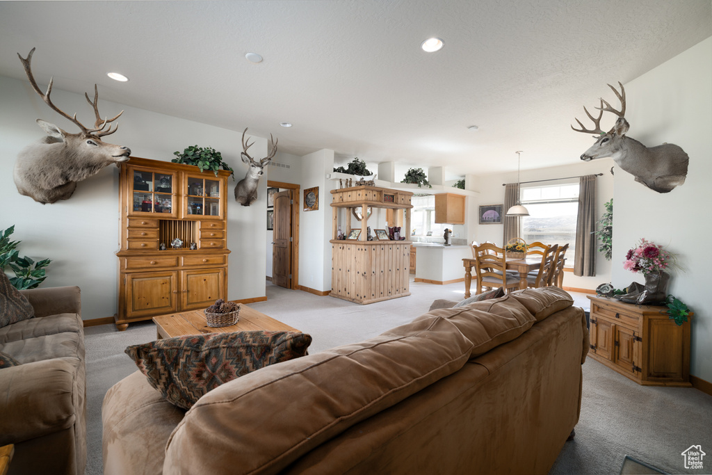 Living area featuring light colored carpet and recessed lighting