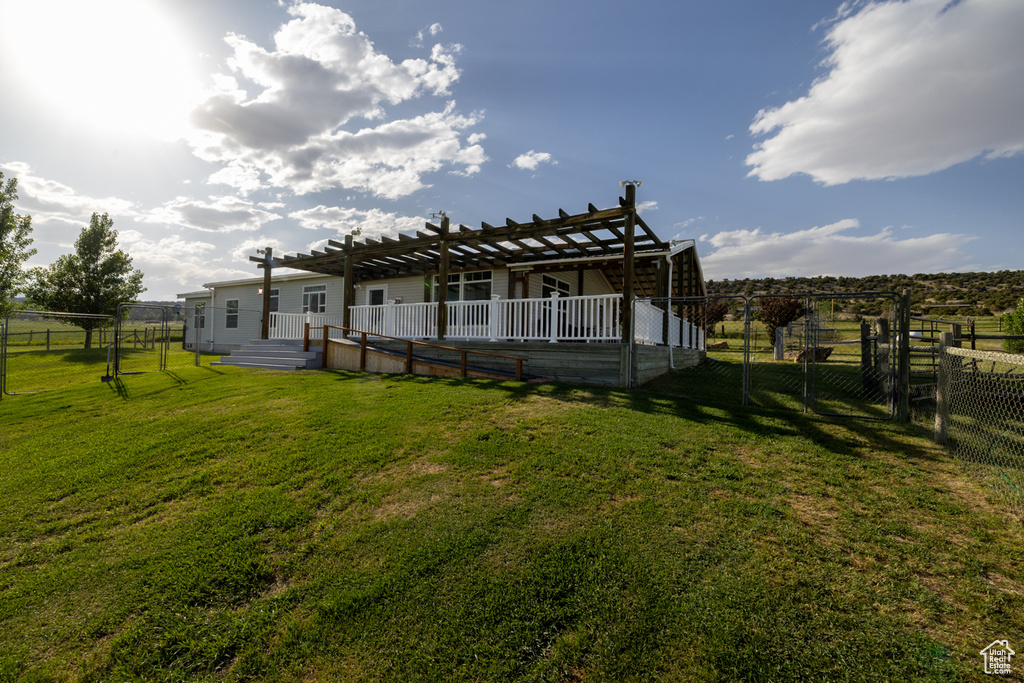 Back of property with a pergola and a wooden deck