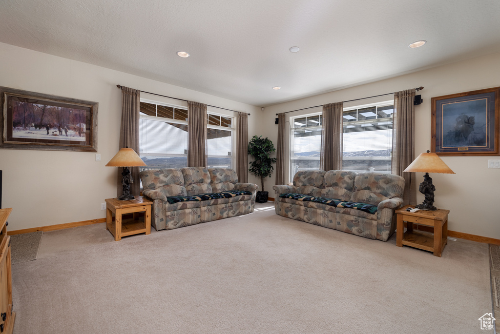 Carpeted living area featuring healthy amount of natural light and recessed lighting